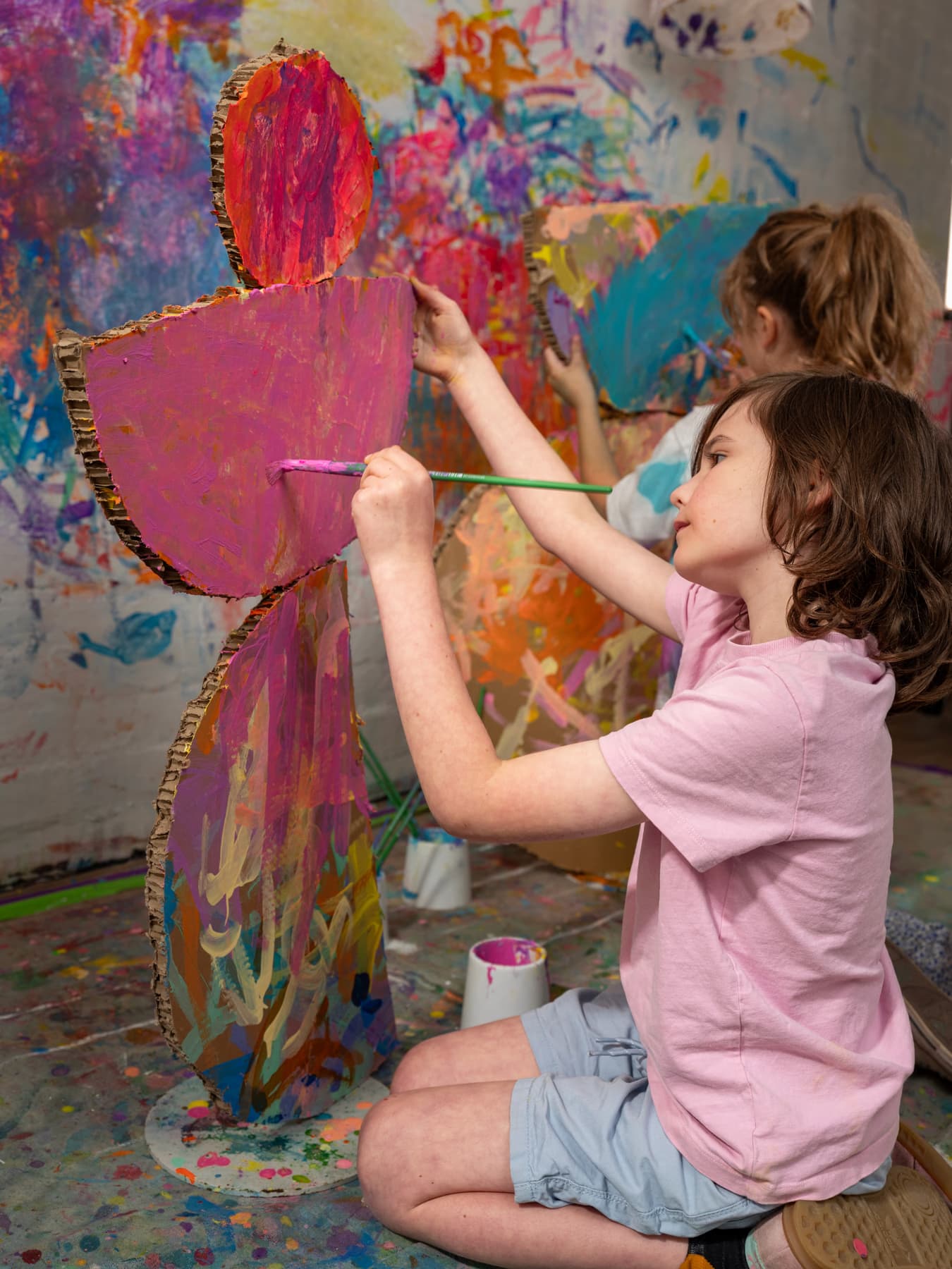 A primary student painting a detailed flower study at the studio.